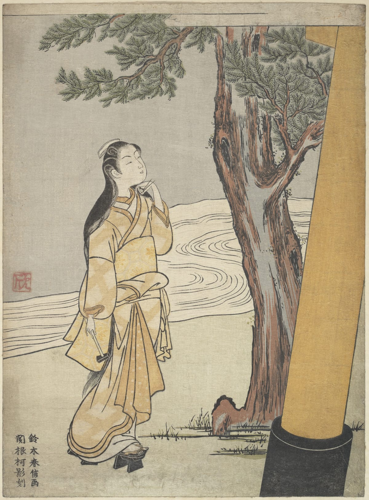 一幅中等大小的木版画：夜里，一位长发女子披着浅黄色的外衣站在神社的大树旁，仰头望向远处；右边是一根粗大的柱子，背景是溪流。左下角有几行小字，左侧有一枚方印。