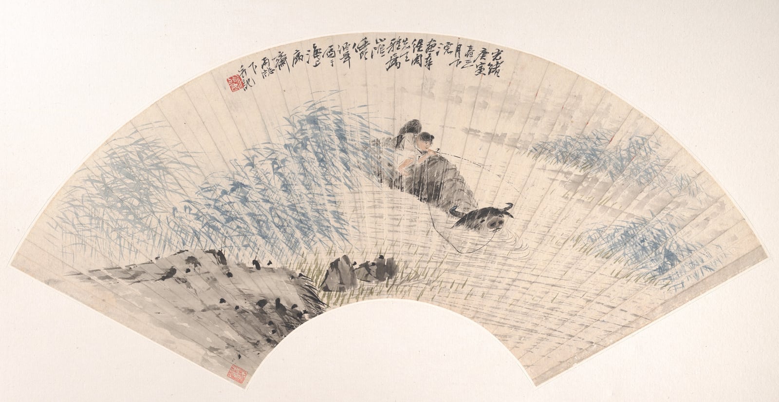 一幅折扇面上的画：上宽下窄的弧形纸面上，用淡青、淡绿的笔触画出一片水草，一个牧童伏在水牛背上，水牛半浸在水里；右上角有几行题字和一方红印，左下角有几块淡墨的石头。