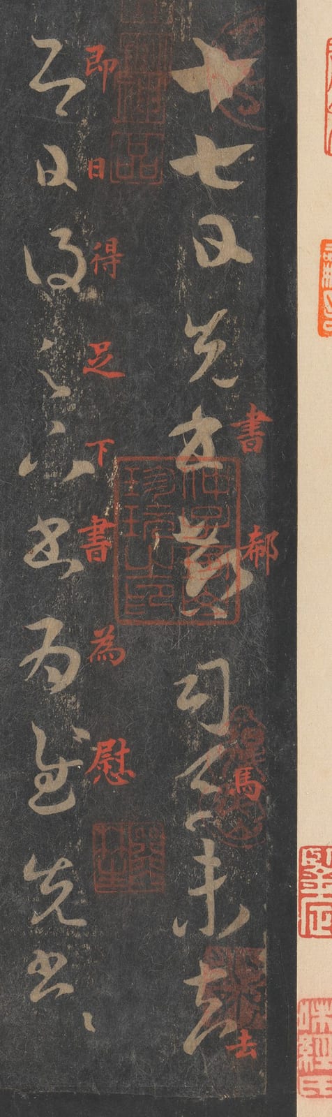 拓片的竖长近景：黑底上白色的草书一列列排下来，最右一列从“十七日”开始；字的边缘有的清楚、有的毛糙，黑底上有斑驳的纹理；红色的小字夹在两列之间。
