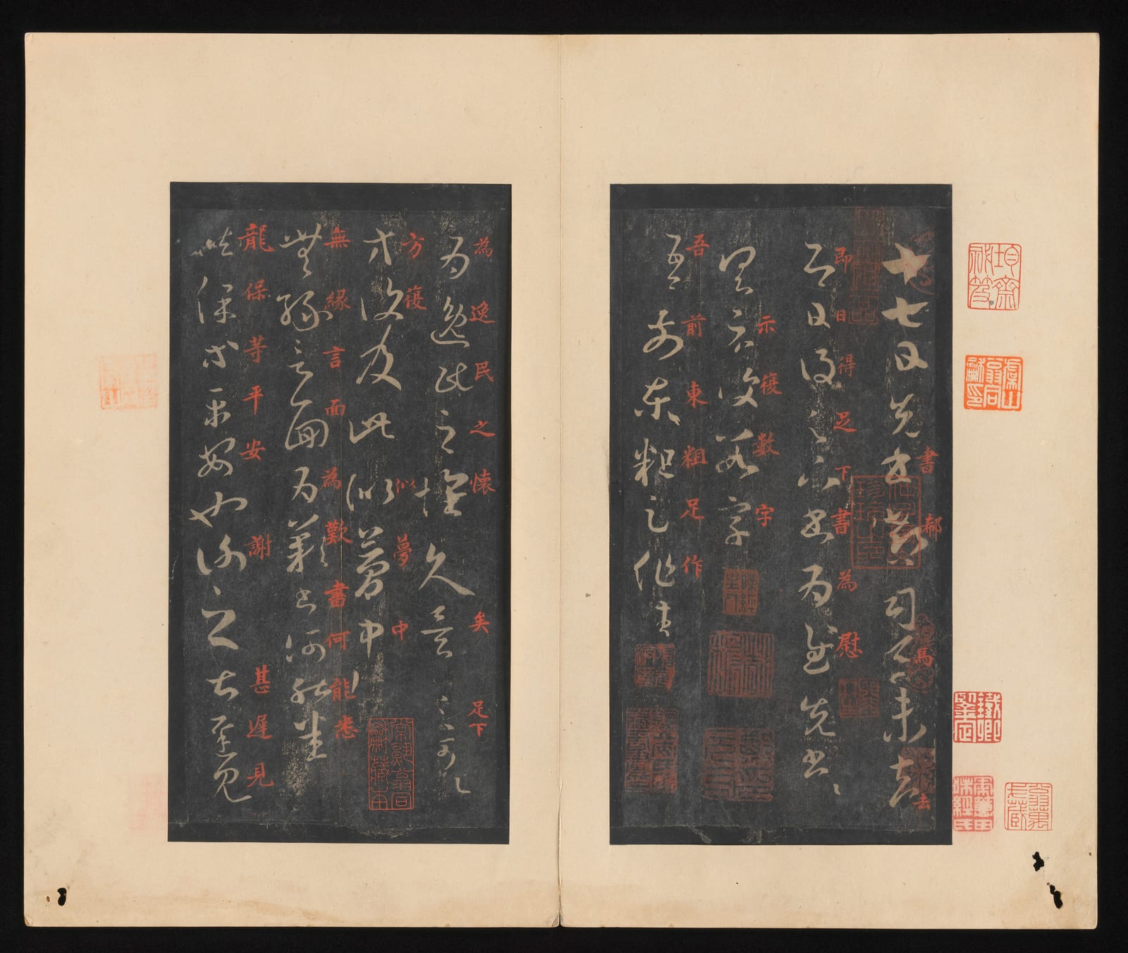 一本打开的册页，左右两面各贴着一块黑底的拓片：黑色上是一个个白色的草书字，从右往左竖着排列，笔画连绵，粗细变化很大；右页第一行开头是“十七日”三个字。字的旁边有一些红色的小字，拓片四周和纸上盖着许多红色的印章。